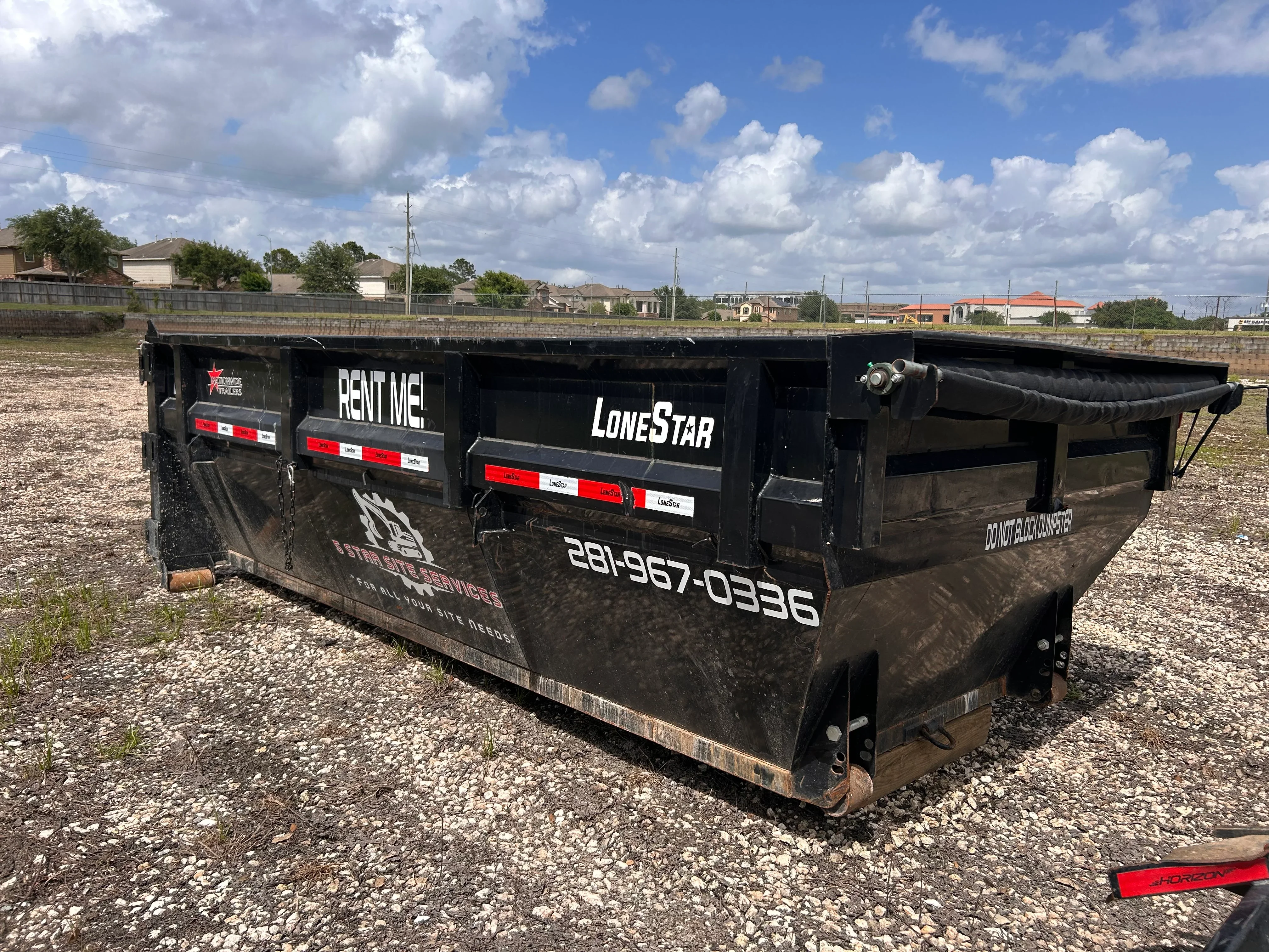 Black steel roll-off dumpster with hydraulic lift and red safety stripes